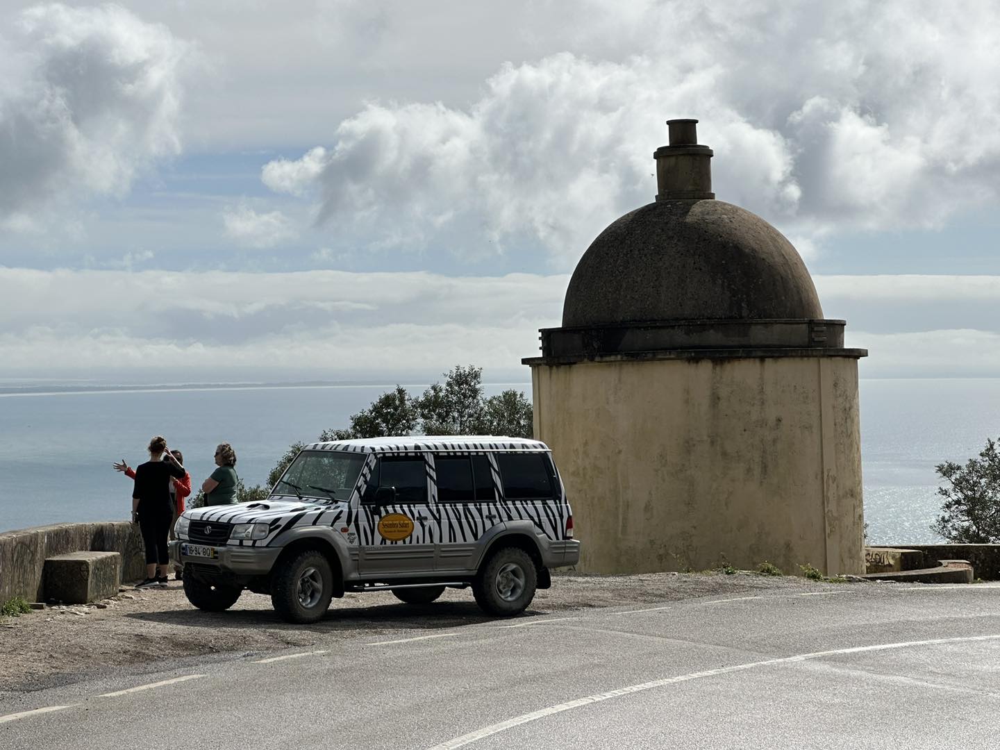Sesimbra Safari jeep at historic coastal viewpoint with dome tower, Setúbal Peninsula, Portugal
