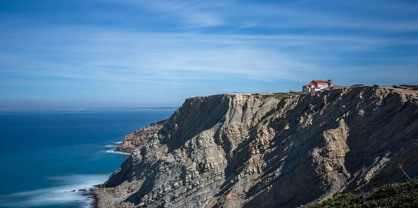 Dramatic sea cliffs with lighthouse on Atlantic coast, Setúbal Peninsula, Portugal