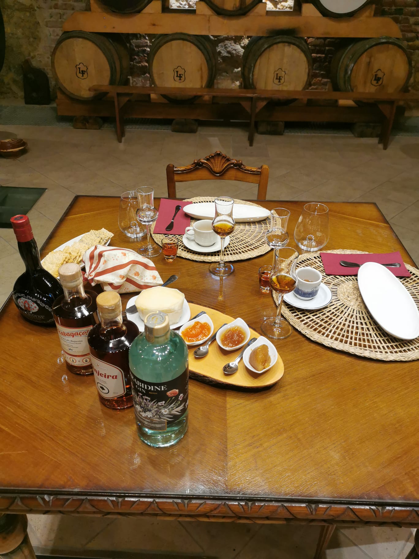 Wine and spirits tasting table with Arrabidine bottles and traditional snacks, Casa do Arrabidine wine cellar, Noite na Adega experience, Setúbal Peninsula