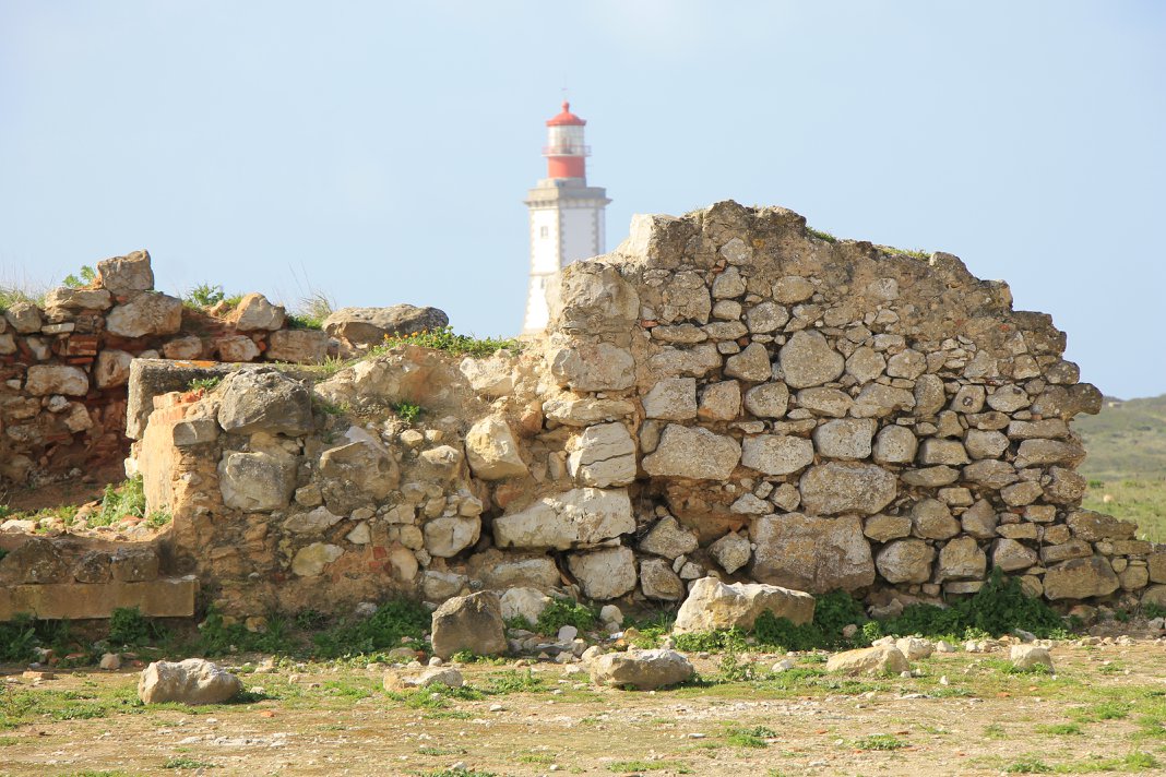 Ancient stone ruins with Cabo Espichel lighthouse in background, historic coastal landmark, Setúbal Peninsula, The Untold Weekend